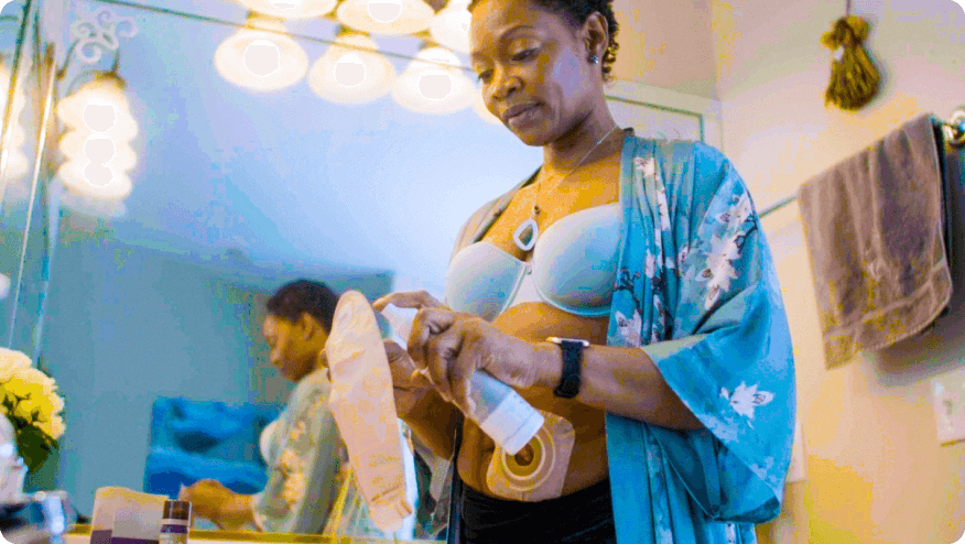 a woman applying a spray to an ostomy pouch