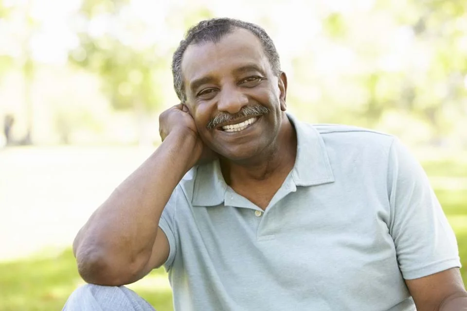 a man smiling with his hand on his head