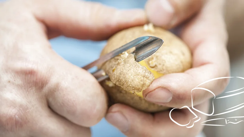 En närbild av en person som skalar en potatis