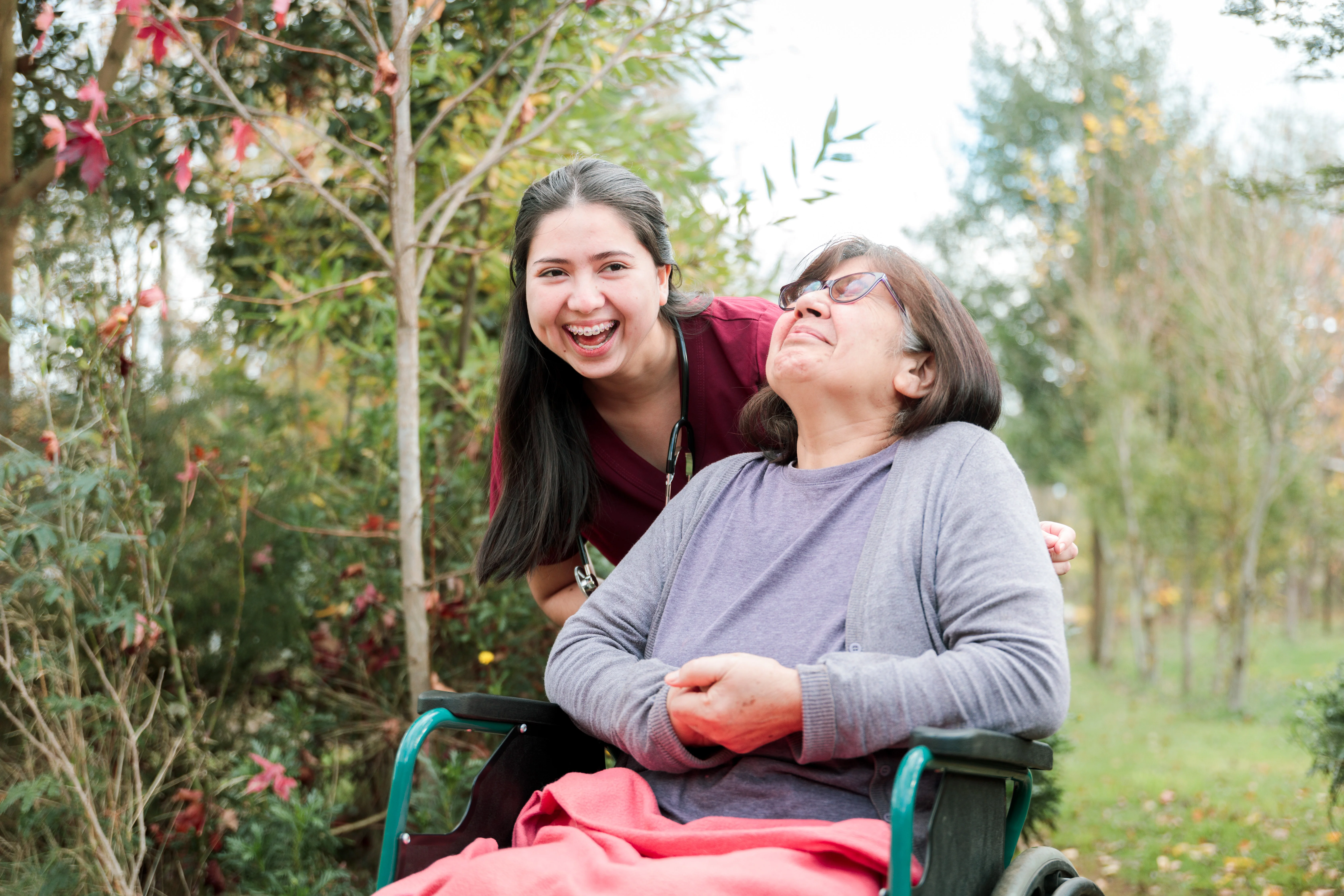 a person and a girl sitting on a bench in a park