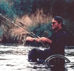 um homem em uma cadeira de rodas pescando