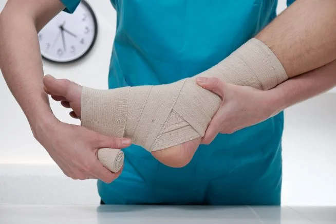 Die Hand einer Person, die den Fuß eines Babys hält