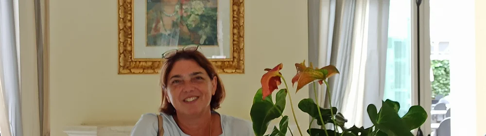 Una donna sorridente con una pianta di fronte a lei