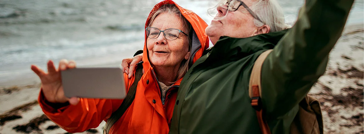 two women taking a selfie on a beach
