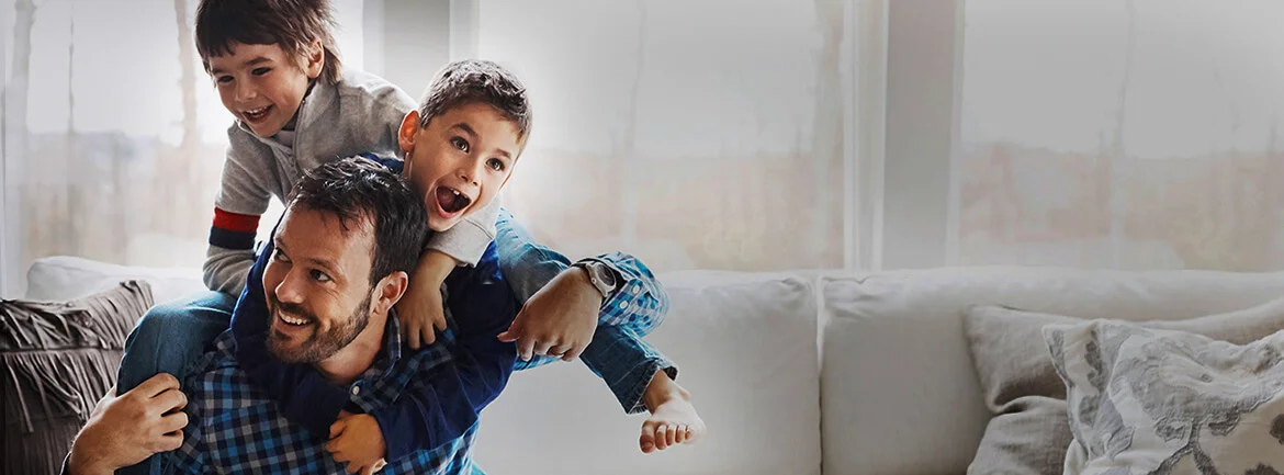 a man holding two boys